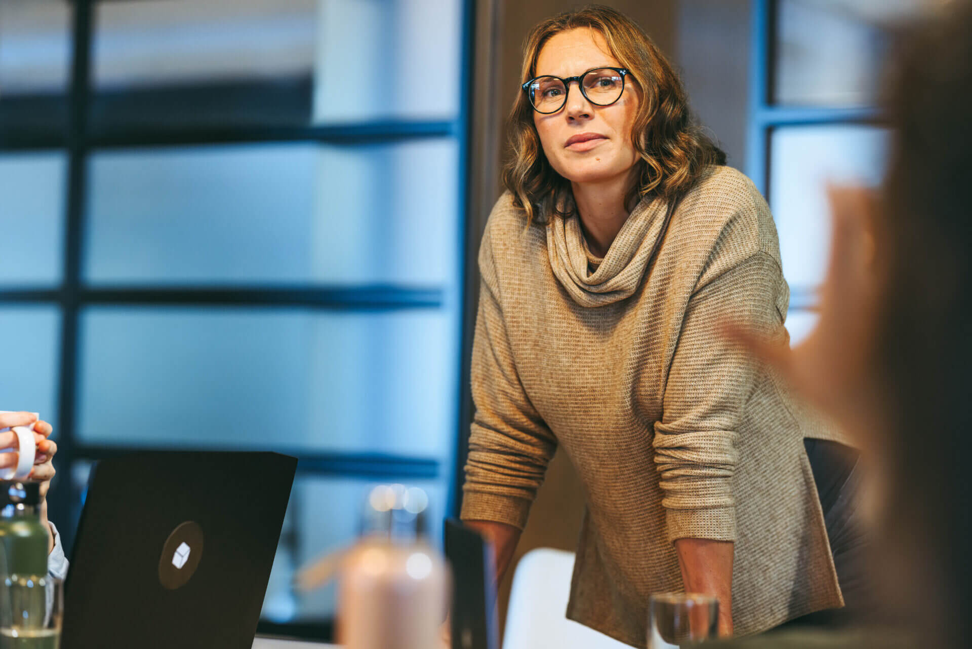 Trainer leading a workshop discussion with international professionals in a modern office.