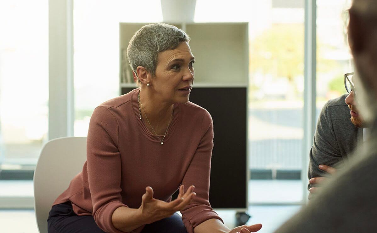 Professional coach facilitating a conversation with international business leaders during a GrowWerk coaching session.