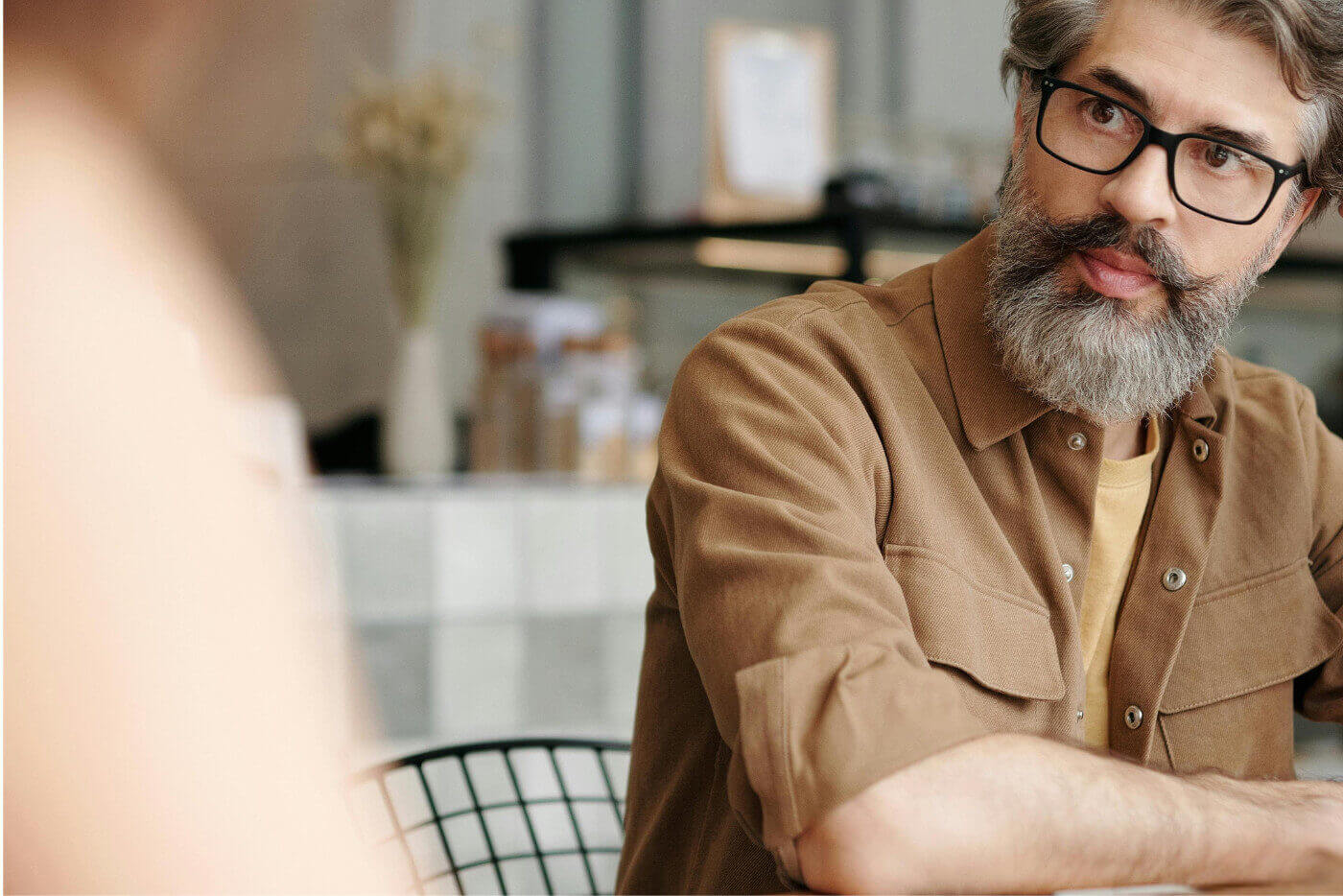Professional in conversation during a coaching session, reflecting and listening attentively.